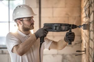 Concrete Pumpers Insurance - Plumber Drilling into Concrete to Gain Access to Pipes