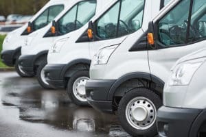 Hard-To-Place Commercial Auto - Closeup View of Multiple Vans of the Same Make and Model Parked In a Line