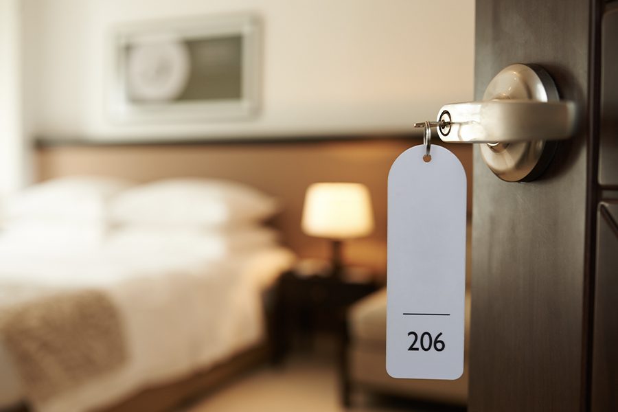 Hotel and Motel Insurance - Closeup View Entering a Hotel Room with Bed and Room Blurred