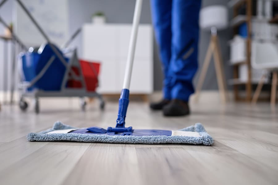 Janitorial and Cleaning Service Bonds - Closeup of Janitor Cleaning the Floor of an Office