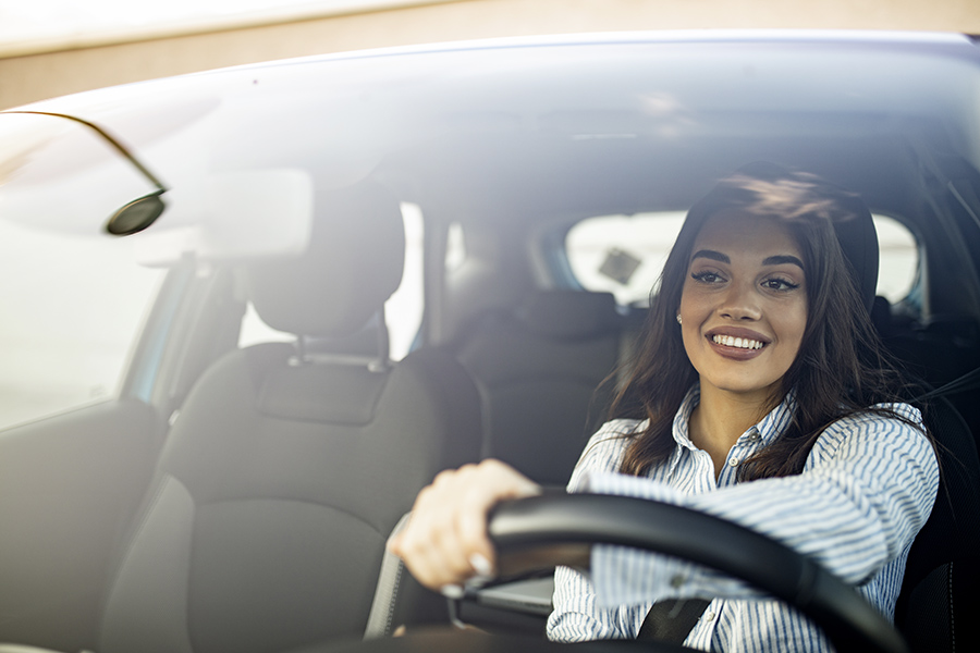 Mechanical Breakdown – Auto Extended Warranty Insurance - Beautiful young happy smiling woman driving her new car at sunset